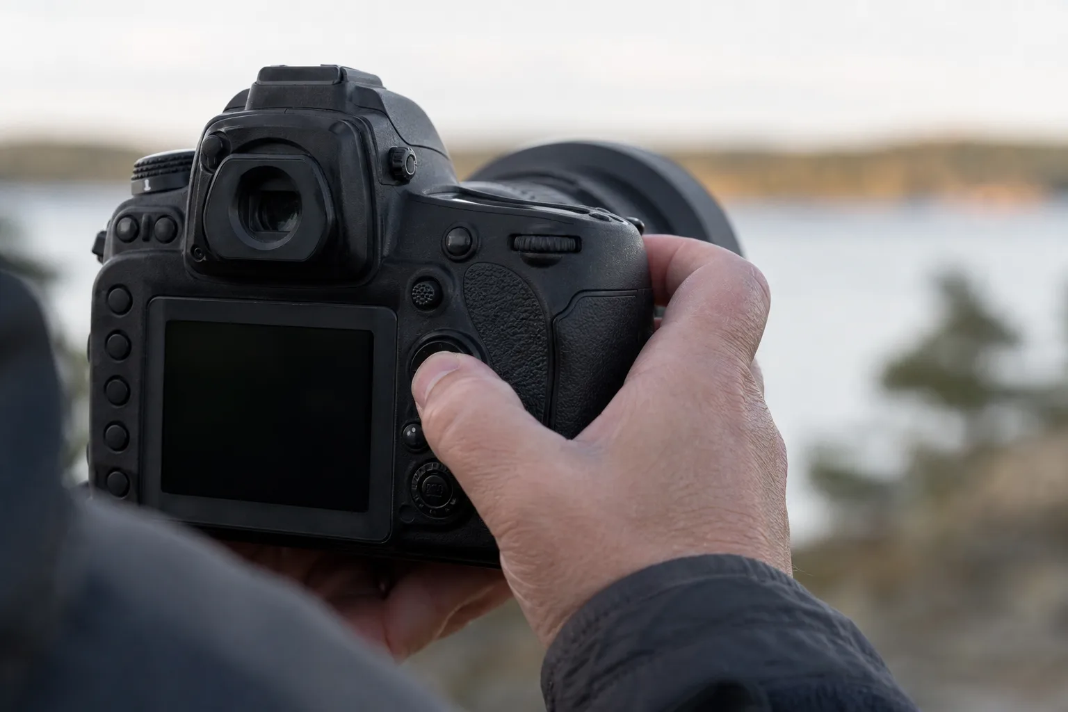Fotografens tumme trycker på en bakre fokusknapp på kamerahuset