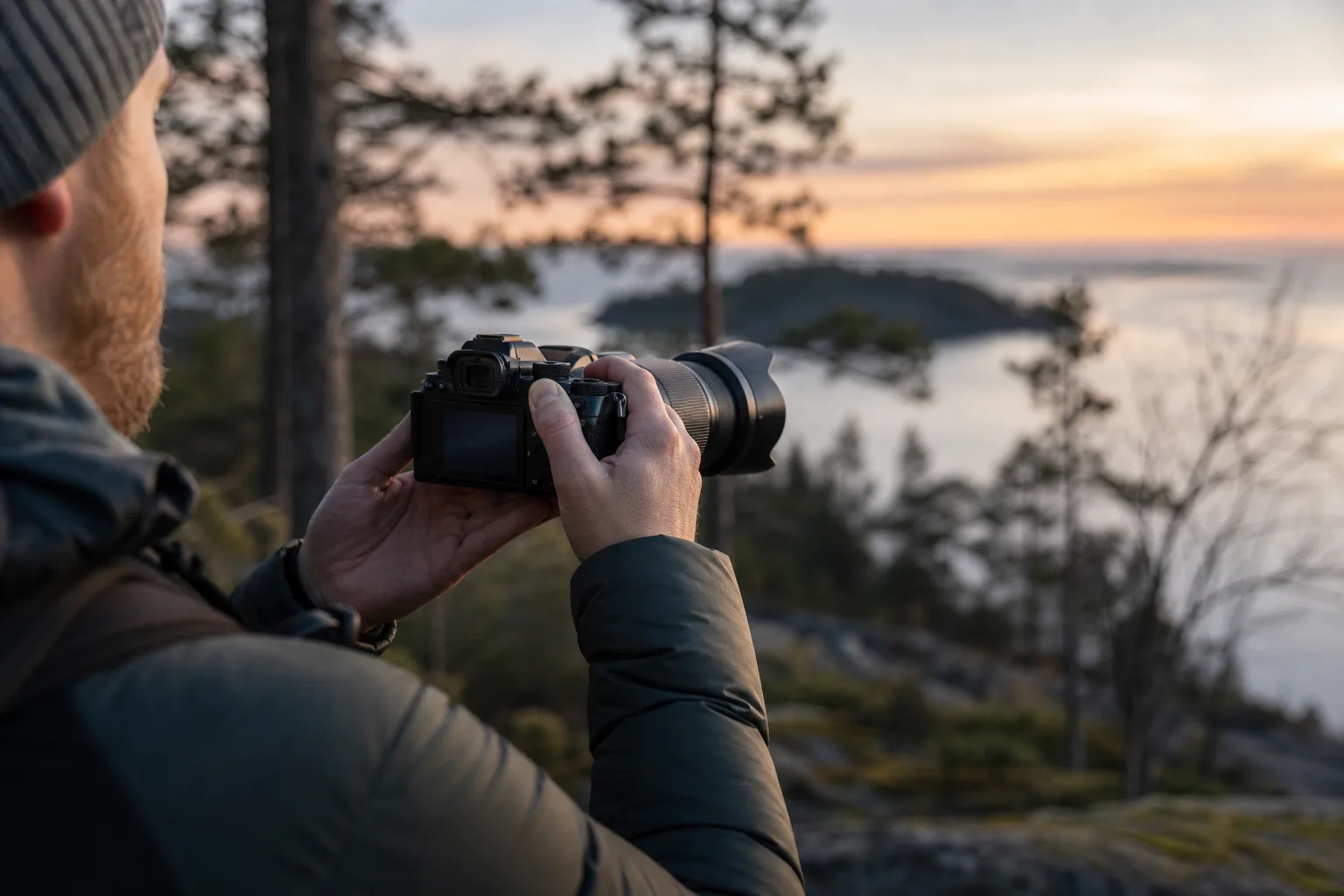 Fotograf håller systemkamera stadigt med båda händerna för en skarp handhållen bild